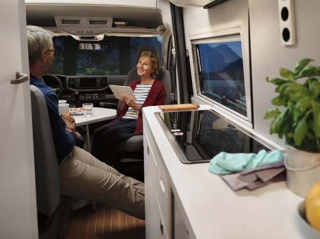 360-Grad-Sitze im Grand California - Mann & Frau sitzen Abends gemeinsam am Tisch im Innenraum